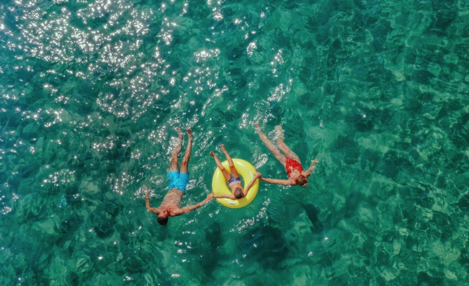 gezin met opblaasband in zeewater